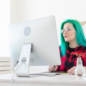 Illustrator, creative, web design concept - Female graphic designer with green hair at work